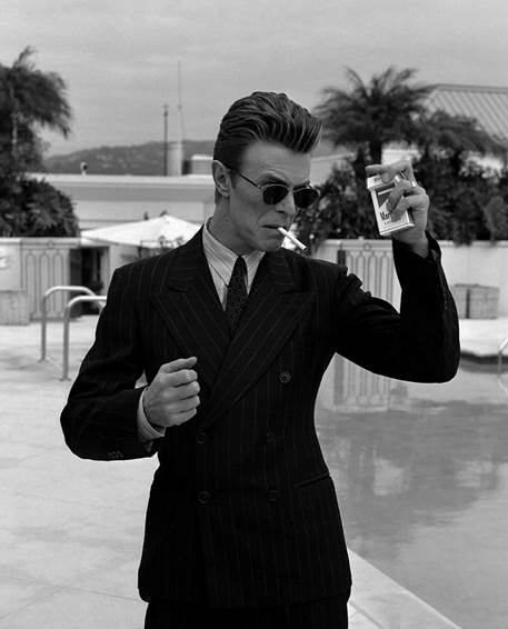 A person in a suit smoking a cigarette  AI-generated content may be incorrect.